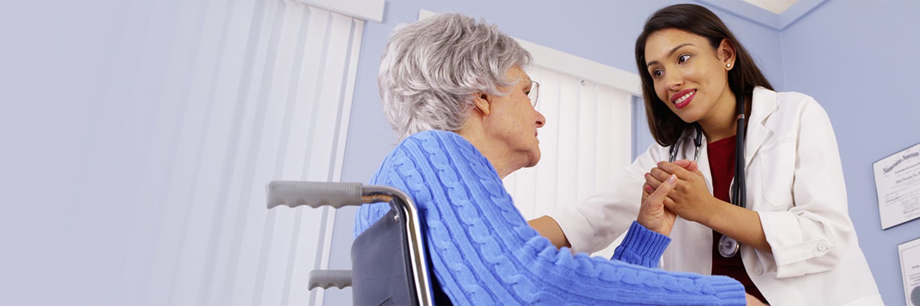 Kindly smiling nurse holding a resident's hand